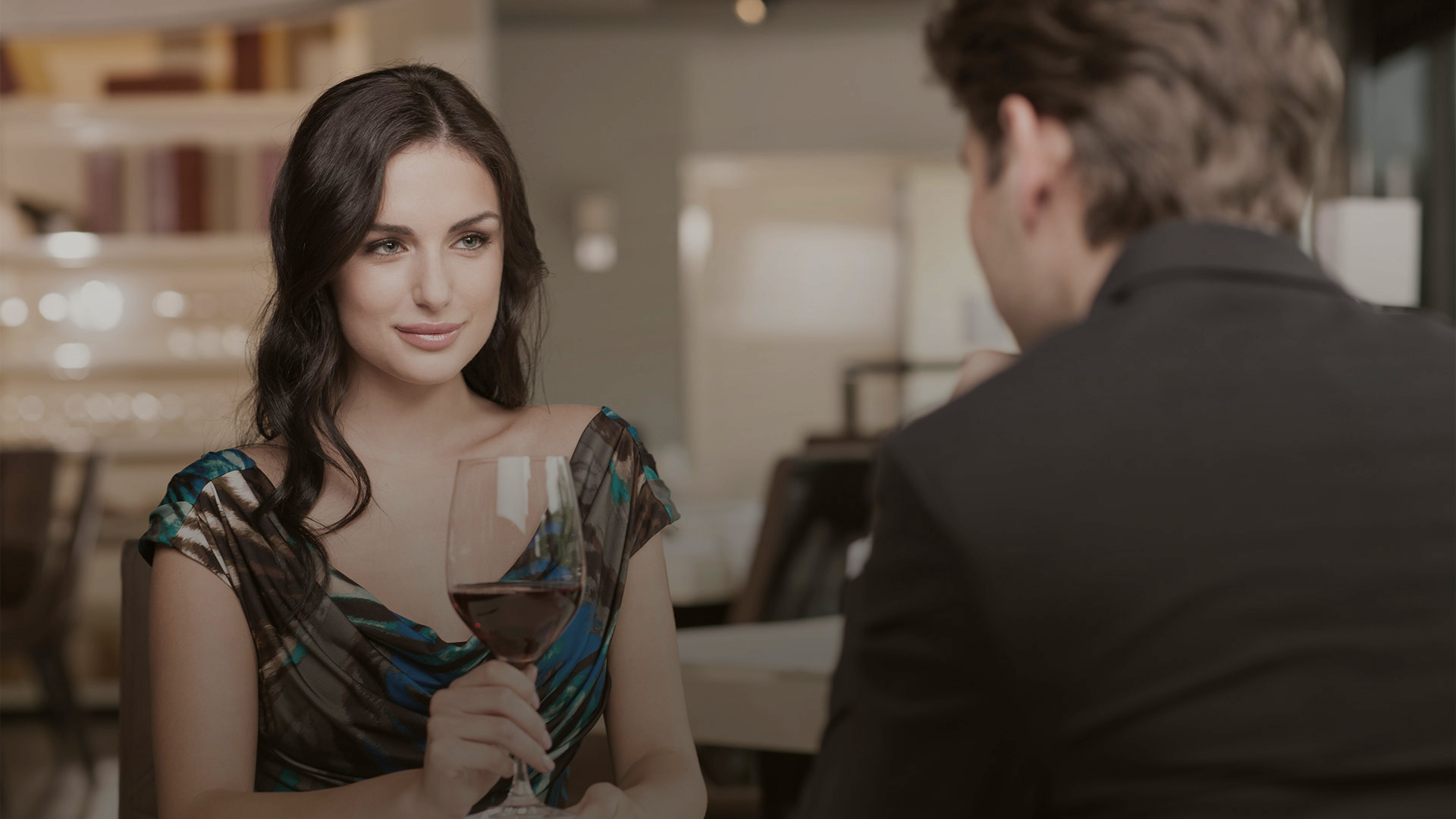 A woman and a man in conversation over wine